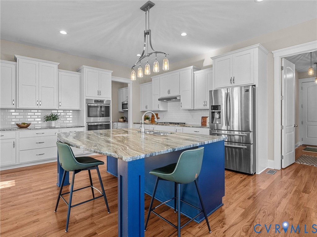 2001 Tulip Hill Drive Midlothian, VA 23112 - Photo 10 of 50 a kitchen with stainless steel appliances granite countertop a stove refrigerator and cabinets