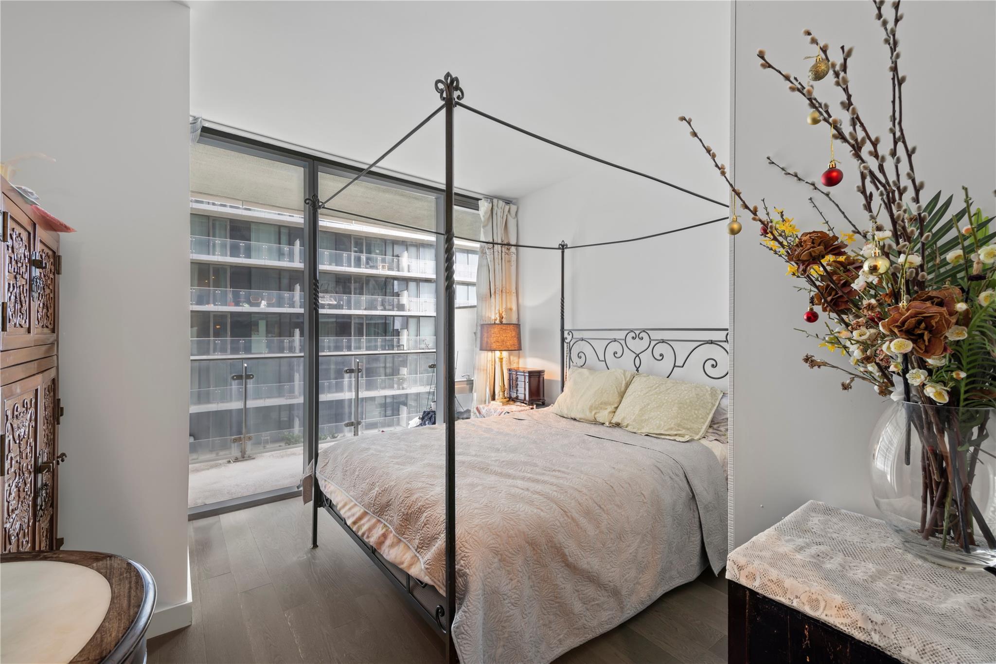 131-05 40 Road, Unit 11M Queens, NY 11354 - Photo 19 of 24 Bedroom with expansive windows and dark wood-style flooring