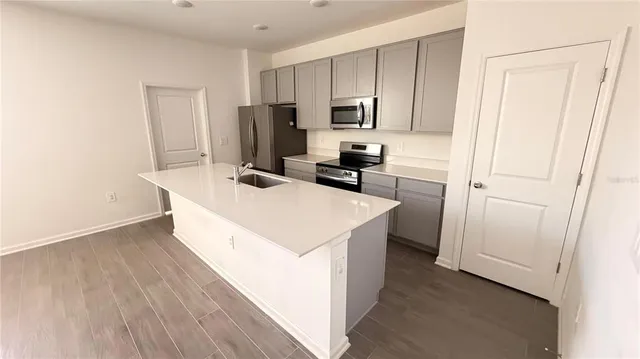 a kitchen with kitchen island a sink appliances and cabinets
