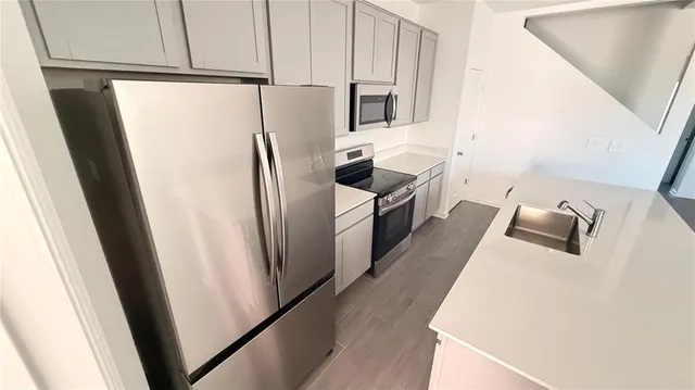 a kitchen with stainless steel appliances a refrigerator and a sink