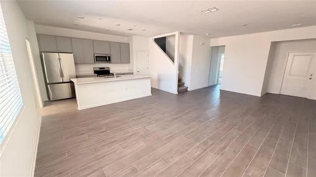 a kitchen with stainless steel appliances a refrigerator and wooden floor