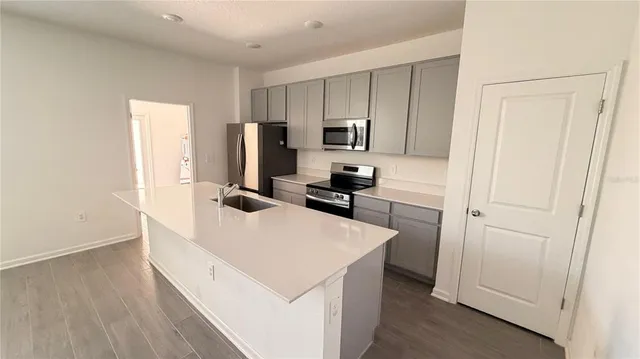 a kitchen with a refrigerator a stove and white cabinets