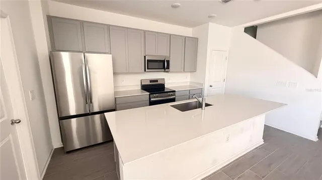 a kitchen with stainless steel appliances a refrigerator stove microwave and sink