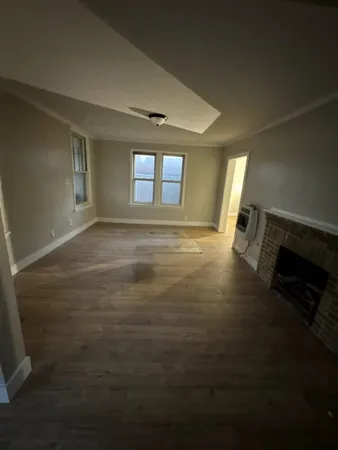 a view of a livingroom with wooden floor and a window