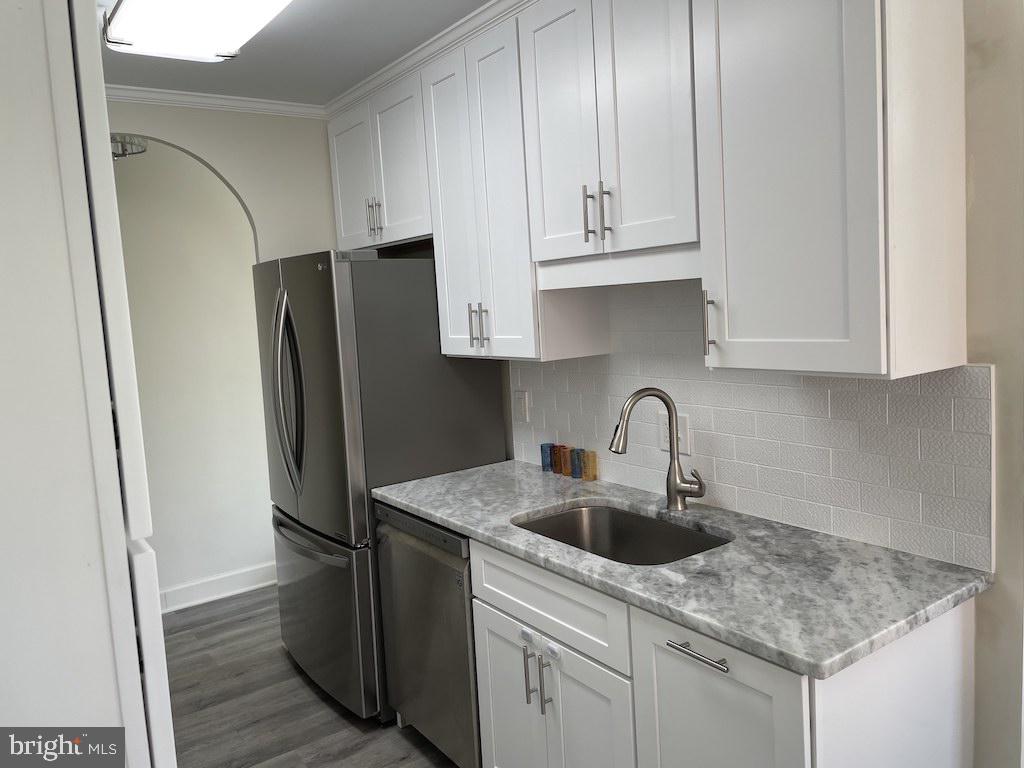 4000 Tunlaw Road Northwest, Unit 516 Washington, DC 20007 - Photo 5 of 35 a kitchen with stainless steel appliances granite countertop a refrigerator sink and cabinets