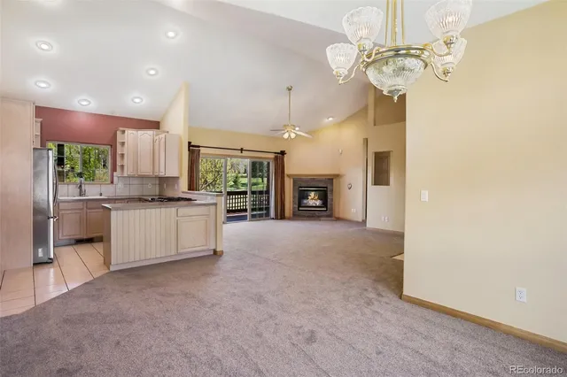 a large kitchen with a sink stainless steel appliances and chandelier