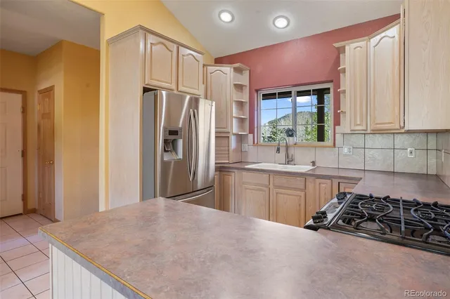 a kitchen with stainless steel appliances granite countertop a refrigerator and a sink