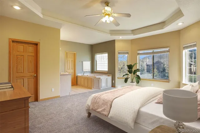 a spacious bedroom with a large bed and a chandelier