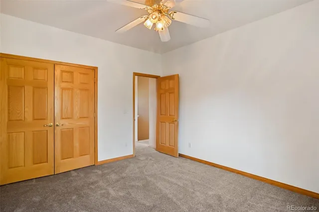 an empty room with windows and ceiling fan
