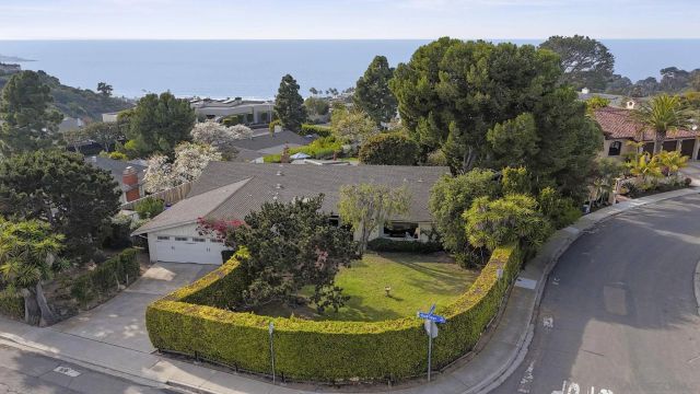 an aerial view of a house with garden space and street view