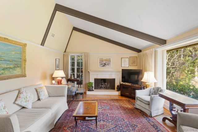 a living room with furniture a fireplace and a floor to ceiling window