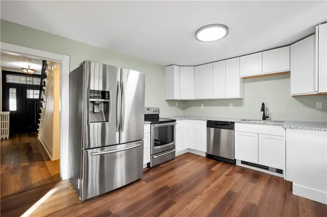 a kitchen with wooden floors and stainless steel appliances