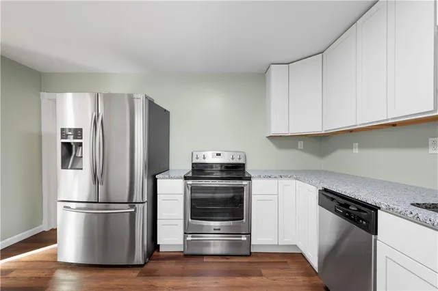 a kitchen with a refrigerator stove and wooden cabinets