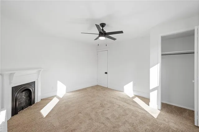 a view of a livingroom with a ceiling fan and a fireplace