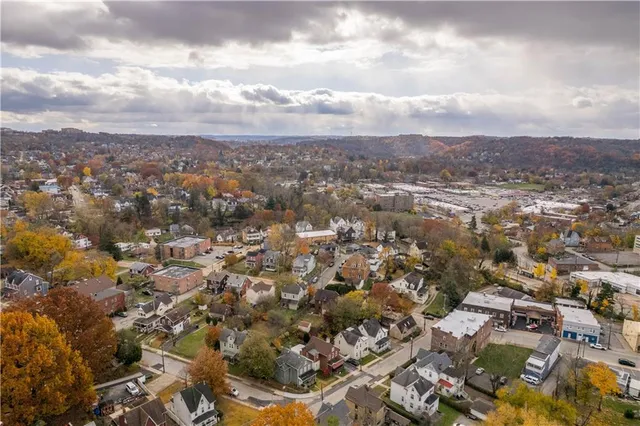 an aerial view of residential house with yard and mountain view in back