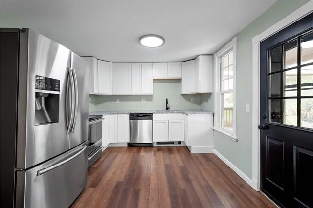 a kitchen with white cabinets and stainless steel appliances