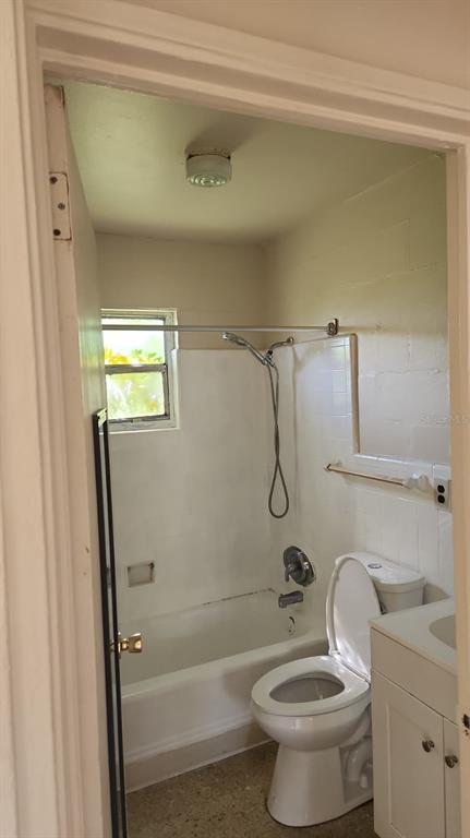 2222 West South Street, Unit 2222 Orlando, FL 32805 - Photo 7 of 7 a bathroom with a granite countertop toilet a sink and bathtub
