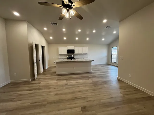 a view of a kitchen with a sink cabinets and wooden floor