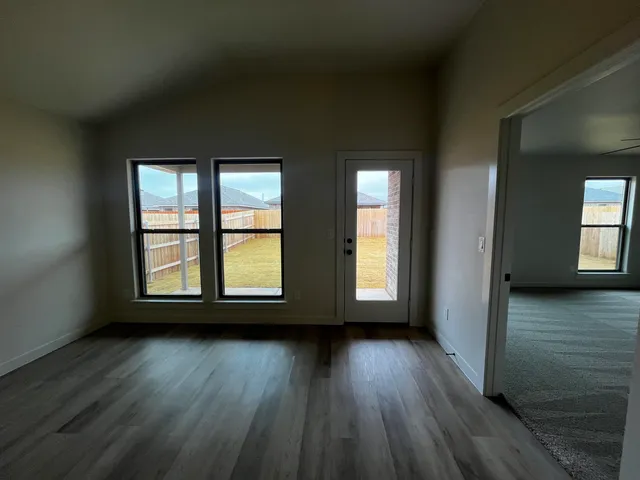 a view of room with wooden floor and windows
