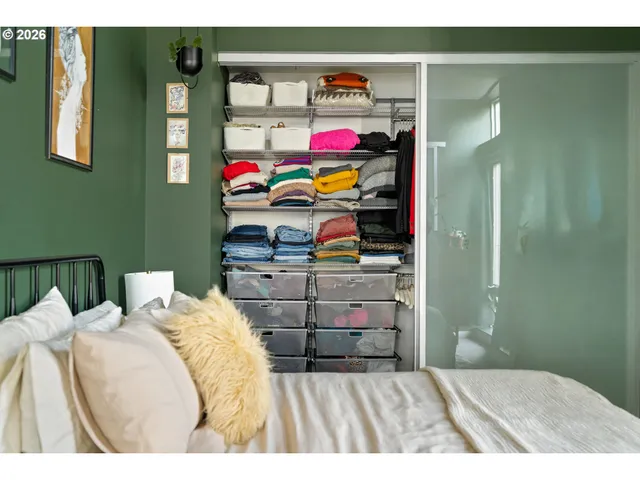 a bedroom with a bed and a painting on the wall