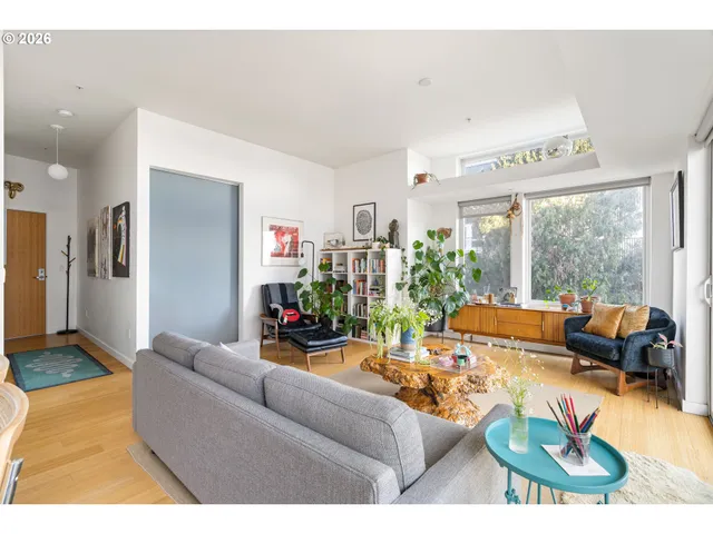 a living room with furniture flowerpot and wooden floor