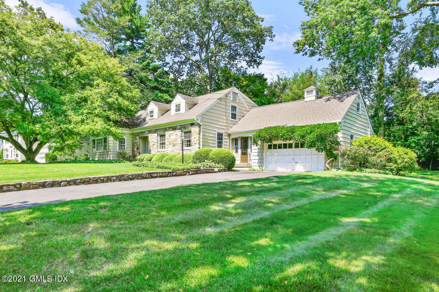 90 Winthrop Drive Riverside, CT 06878 - Photo 1 of 27 a front view of a house with a garden and trees