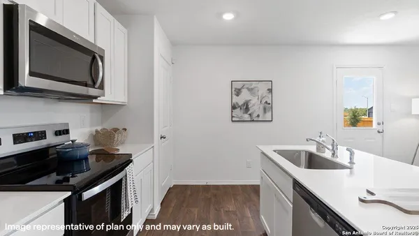 a kitchen with stainless steel appliances a sink a stove a microwave a counter top space and cabinets