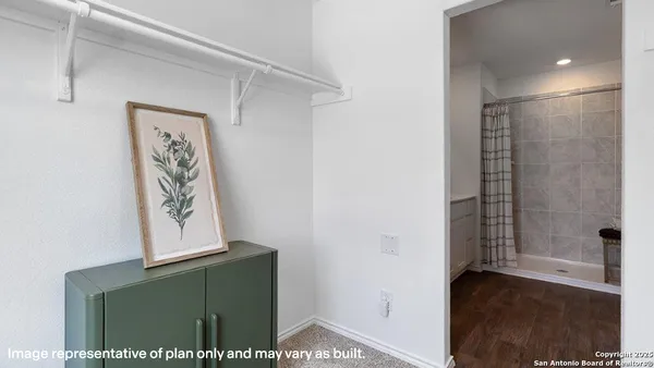 a view of a hallway with wooden floor and a bathroom