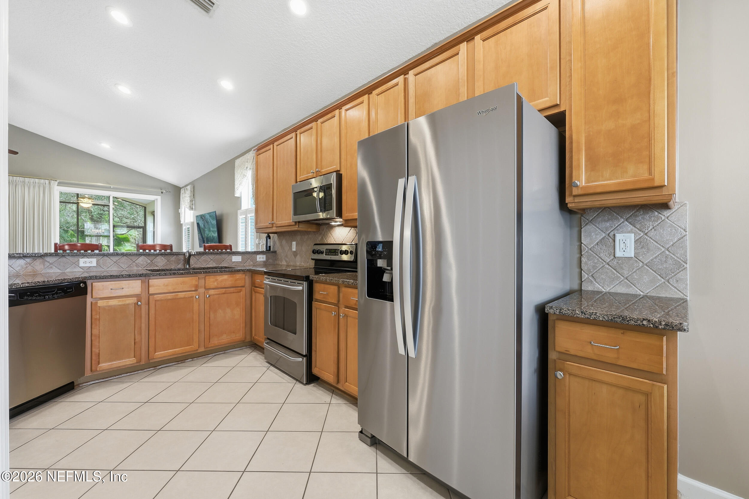 720 Copperhead Circle St. Augustine, FL 32092 - Photo 11 of 65 a kitchen with stainless steel appliances granite countertop a refrigerator sink and cabinets