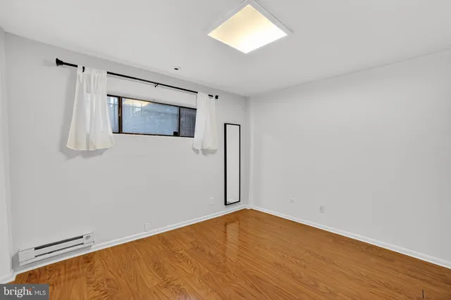 a view of empty room with wooden floor