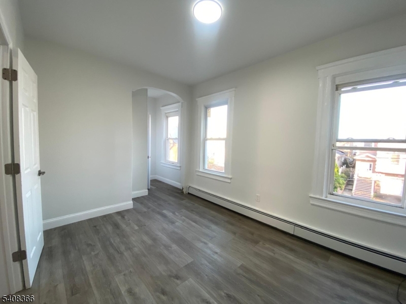 223 John Street Elizabeth, NJ 07202 - Photo 2 of 6 a view of an empty room with wooden floor and a window