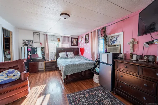 a bedroom with furniture and wooden floor