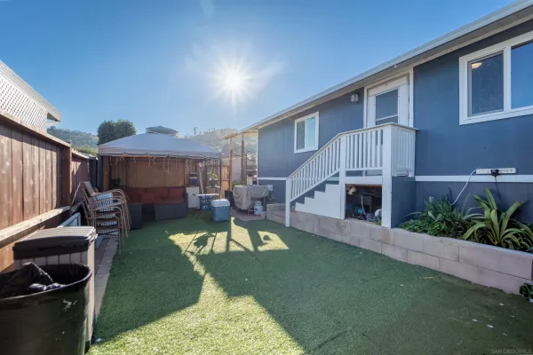a view of a house with backyard sitting area and furniture