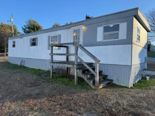 a view of a house with a yard and wooden fence