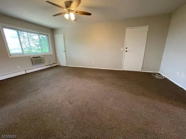 an empty room with a window and a fan