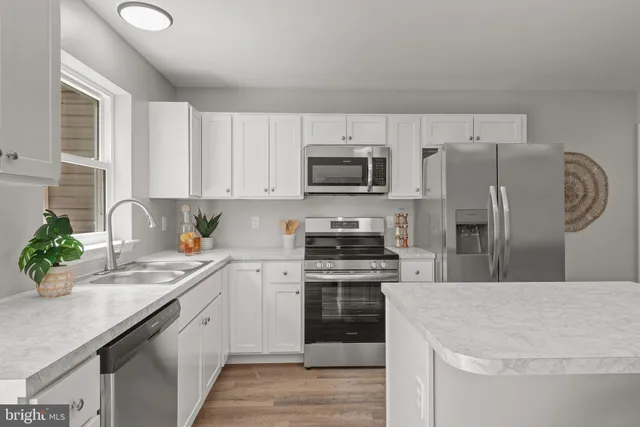 a kitchen with a sink a microwave a refrigerator and cabinets