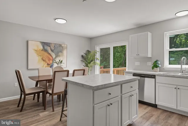 a kitchen with a table chairs and wooden floor