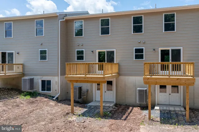 a front view of a house with plants and trees
