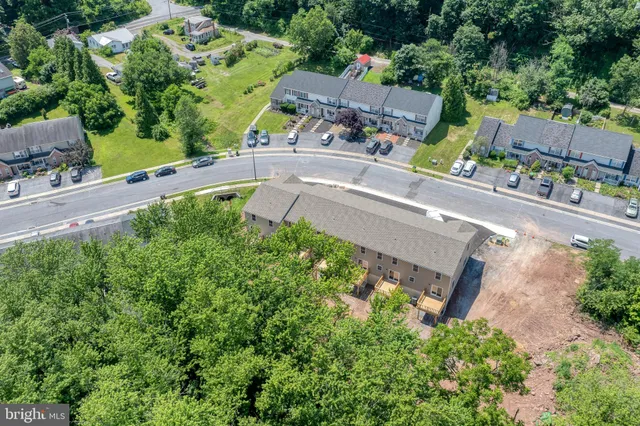 an aerial view of a house with a garden and trees