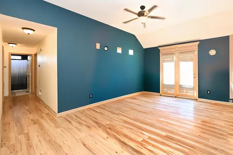 a view of a livingroom with a chandelier fan and a window