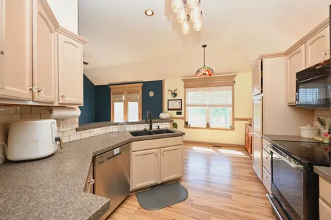 a kitchen that has a sink stove and wooden cabinets