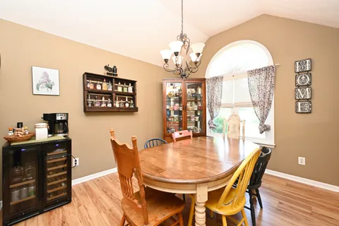 a dining room with furniture a chandelier and wooden floor