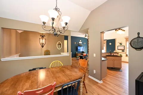a view of a dining room with furniture a chandelier and wooden floor