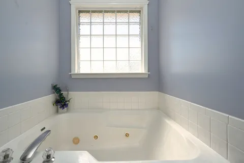 a bath tub sitting in a bathroom next to a window