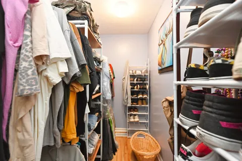 a view of walk in closet with clothes and shoes