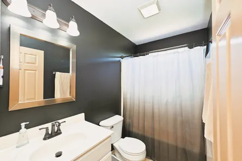 a bathroom with a sink vanity mirror and toilet