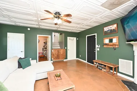 a bedroom with a bed ceiling fan and a window