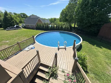 a view of a swimming pool with a patio and garden