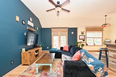 a living room with furniture fireplace and a large window