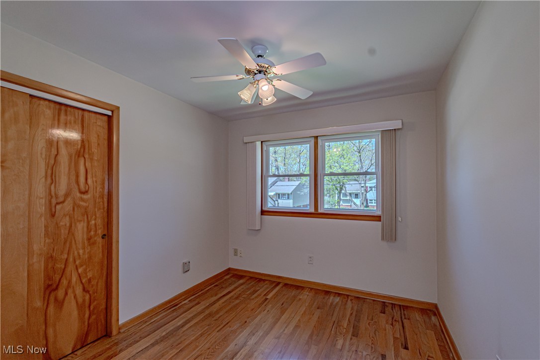 11153 Stoneham Road Cleveland, OH 44130 - Photo 12 of 18 Unfurnished bedroom with a closet, a ceiling fan, light wood-style flooring, and baseboards